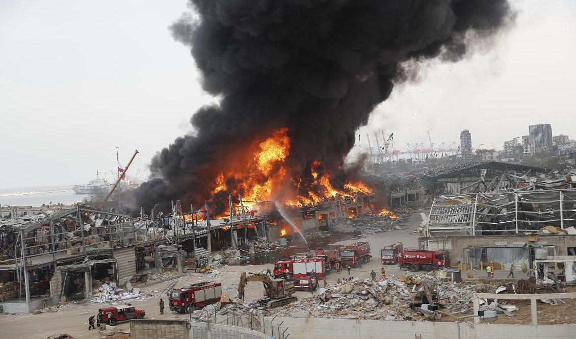 Tjock svart rök stiger från branden i Beiruts hamn. Foto: Hussein Malla/AP/TT