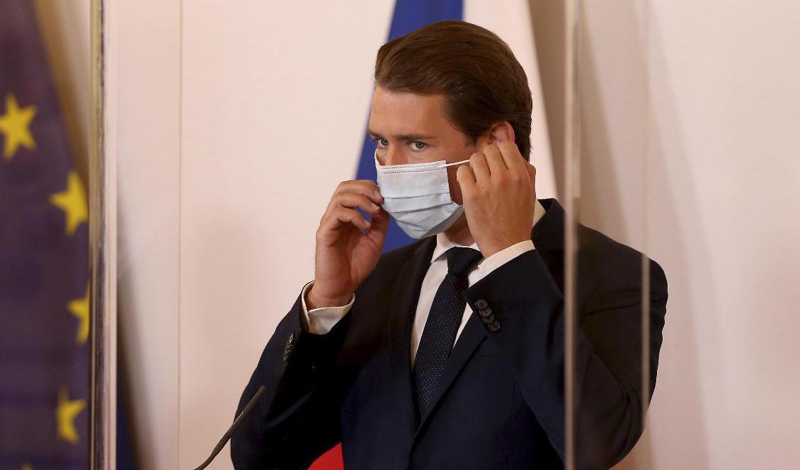 Österrikes förbundskansler Sebastian Kurz rättar till sitt munskydd vid en presskonferens i Wien. Foto: Ronald Zak/AP/TT