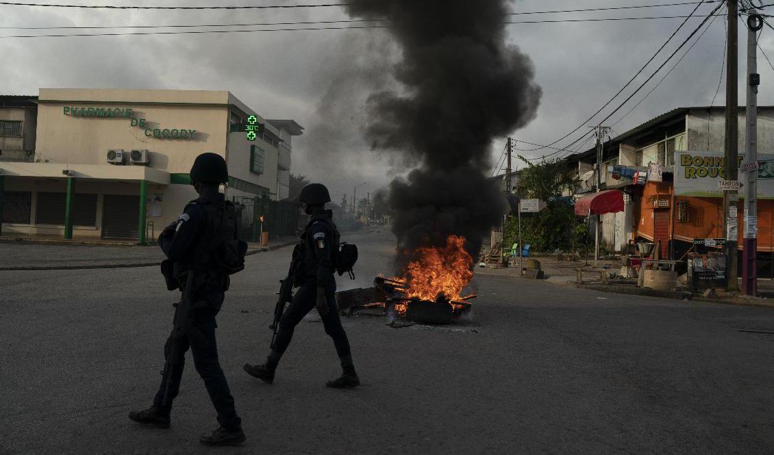 Poliser passerar protester i Abidjan den 3 november. Våldet efter presidentvalet i Elfenbenskusten fortsätter, sedan oppositionen vägrat att godta resultatet. Arkivbild. Foto: Leo Correa/AP/TT