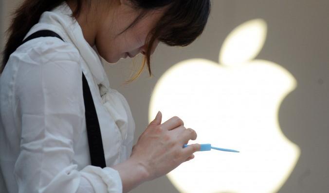 



En kvinna på en Apple-affär i Shanghai kollar sin mobiltelefon. Foto: Peter Parks/AFP/Getty Images                                                                                                                                                                                