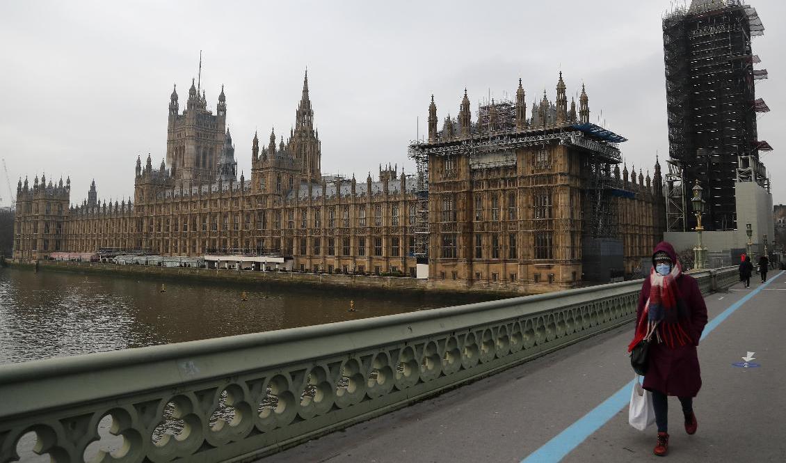 En kvinna går över Westminster Bridge under fredagen, samma dag som nya regler för resenärer till England meddelas. Foto: Frank Augstein/AP/TT