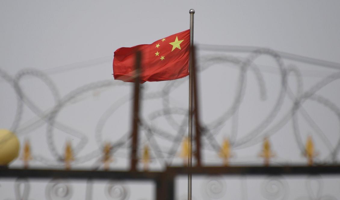 
Bilden är från den 4 juni 2019 och visar den kinesiska flaggan bakom taggtråd runt en anläggning i Yangisa i södra Kashgar i Xinjiangregionen i Kina. Foto: Greg Baker/AFP via Getty Images                                            