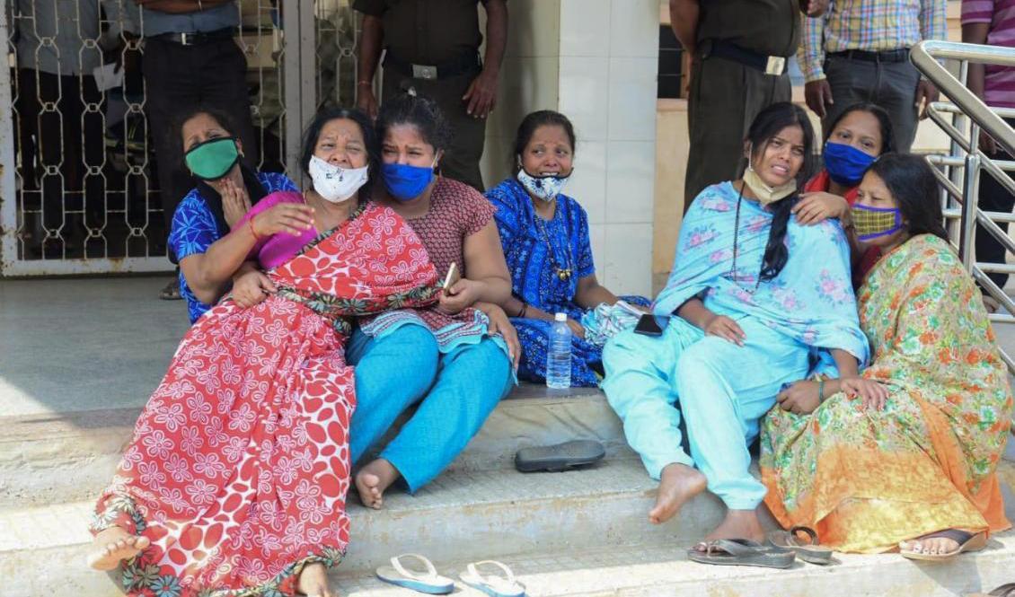 Anhöriga till covidpatienter vakar utanför ett statligt sjukhus i Chamarajanagar i delstaten Karnataka. Foto: AP/TT