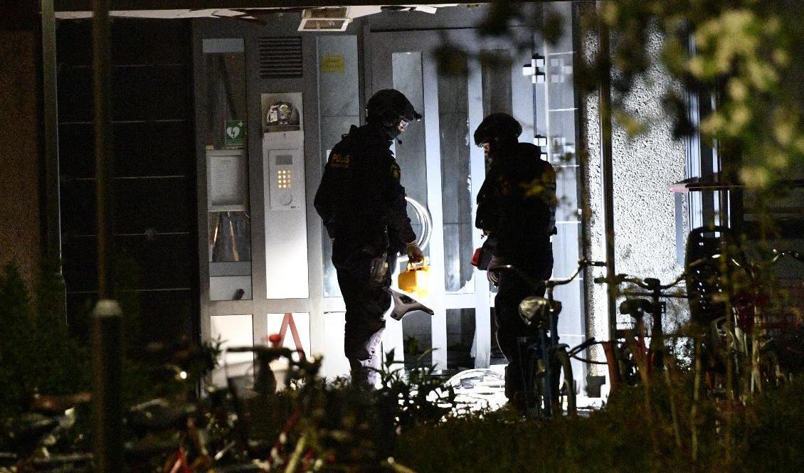 Polisens bombtekniker undersöker en flerfamiljsfastighet i bostadsområdet Lindeborg i Malmö där entréporten skadats efter en detonation. Foto: Johan Nilsson/TT