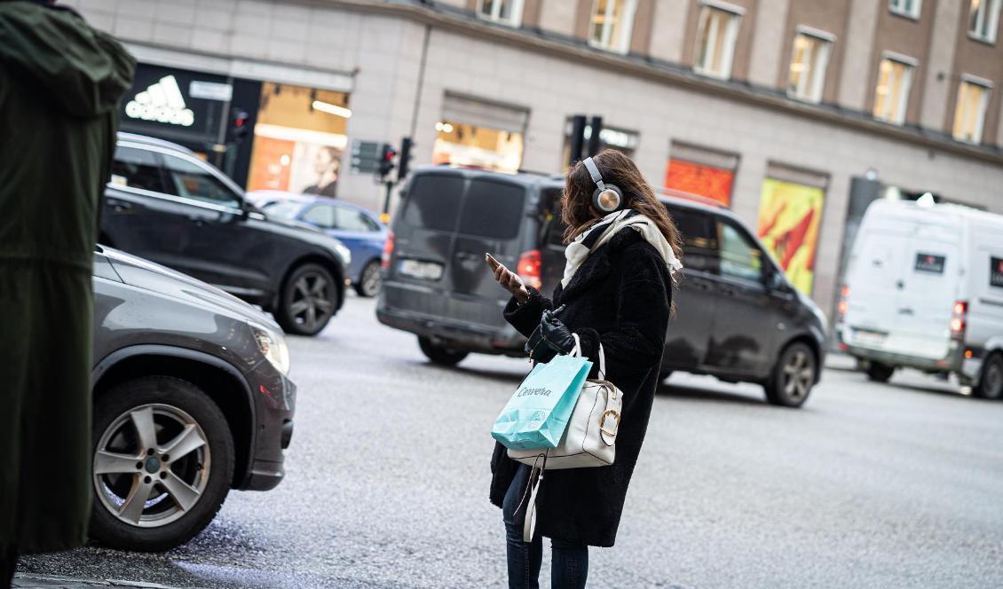 
En kvinna tittar på sin mobiltelefon i centrala Stockholm. Foto: Sofia Drevemo                                            
