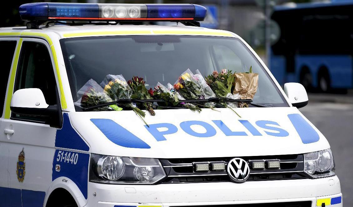 Blommor på en polisbil i Biskopsgården efter att en polis sköts till döds i Biskopsgården på Hisingen i Göteborg. Foto: Björn Larsson Rosvall/TT