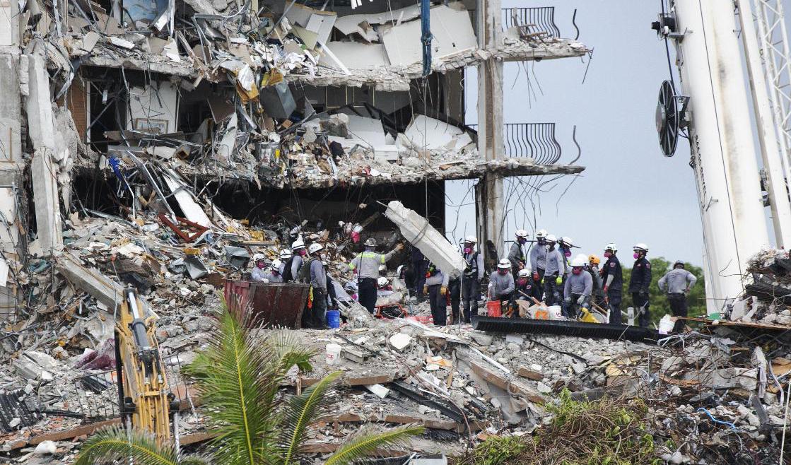 Sök- och räddningsarbetare tar bort en stor bit betong från rasmassorna, en vecka efter det att delar av ett flervåningshus kollapsade i Surfside. Foto: Emily Michot/AP/TT