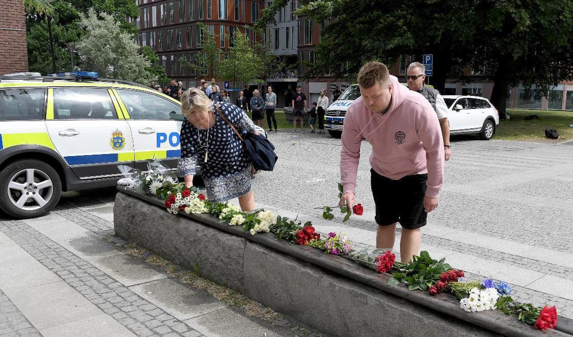 Personer lägger blommor utanför polishuset i Göteborg för att hedra den polis som sköts till döds i Biskopsgården. Foto: Tommy Holl/TT