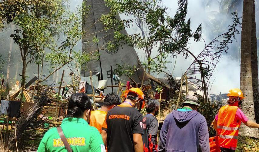 Räddningsarbetare söker efter överlevare och kvarlevor sedan ett C-130 Hercules-flygplan kraschat. Foto: AP/TT