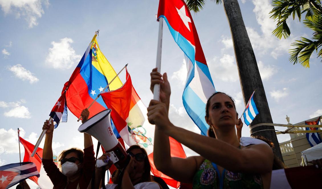 Människor i Miami USA håller upp flaggor från Kuba, Peru och Venezuela och visar sitt stöd för folket i Kuba som demonstrerar mot den kommunistiska diktaturen. Foto: Eva Marie Uzcategui/AFP via Getty Images