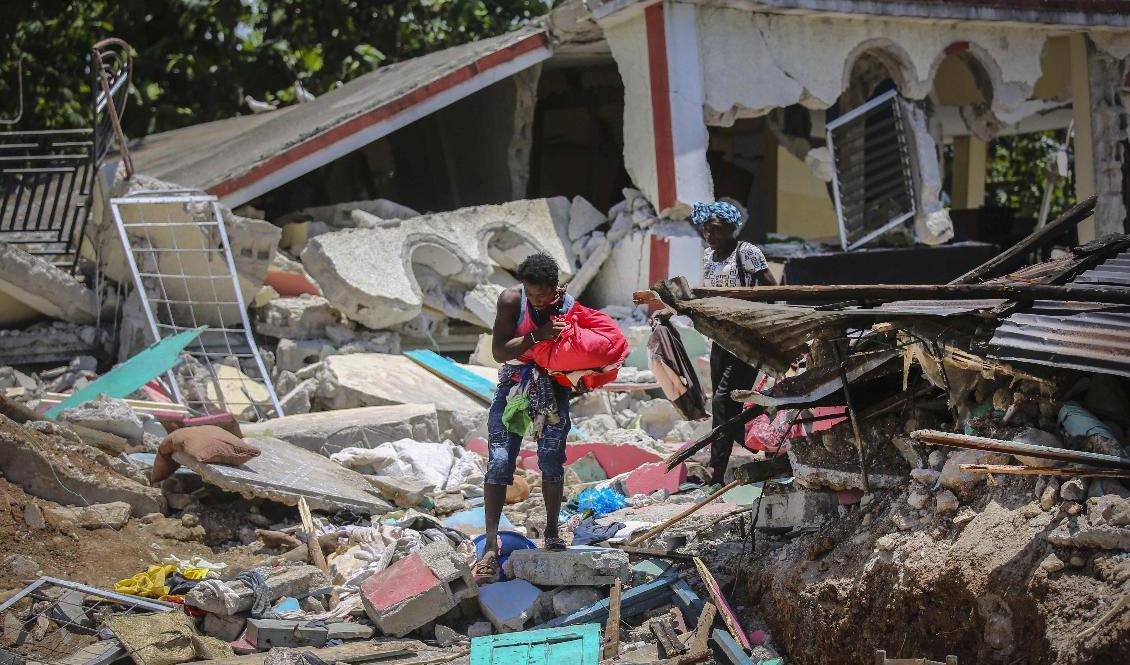 En överlevande försöker rädda vad som finns kvar av hemmet i Les Cayes. Foto: Joseph Odelyn/AP/TT