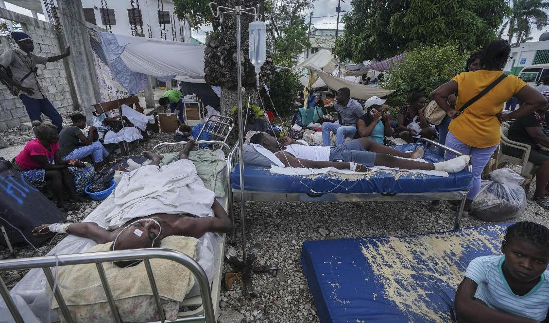 Skadade efter lördagens jordskalv vårdas utomhus i Les Cayes. Foto: Fernando Llano/AP/TT
