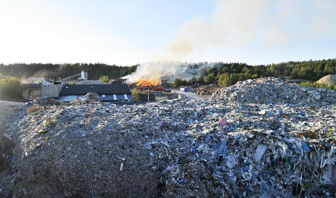 Brandrök och eldslågor på en soptipp i Kassmyra i Botkyrka utanför Stockholm. Släckningsarbetet kan ta lång tid, enligt brandförsvaret. Foto: Stina Stjernkvist/TT