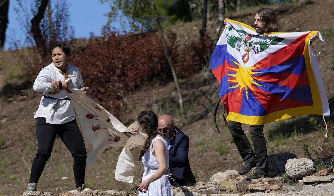 En polis försöker stoppa protester från tibetaner under eldtändningsceremonin i Olympia. Foto: Thanassis Stavrakis/AP/TT