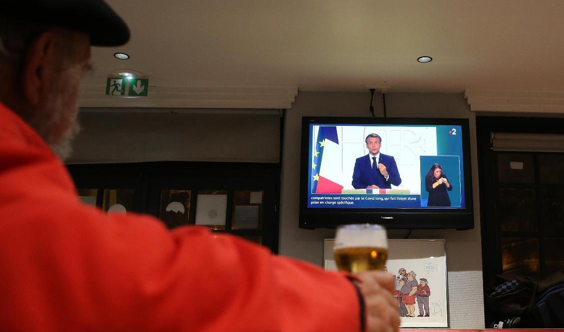 En man ser Macrons tv-tal på en bar i Baoynne i sydvästra Frankrike. Foto: Bob Edme/AP/TT