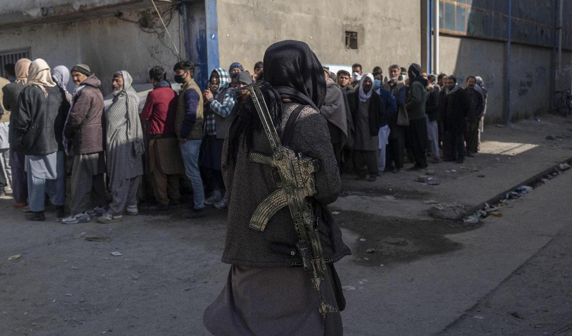 Afghanska medborgare köar för att få pengar av FN:s livsmedelsprogram. Arkivbild. Foto: Petros Giannakouris/AP/TT