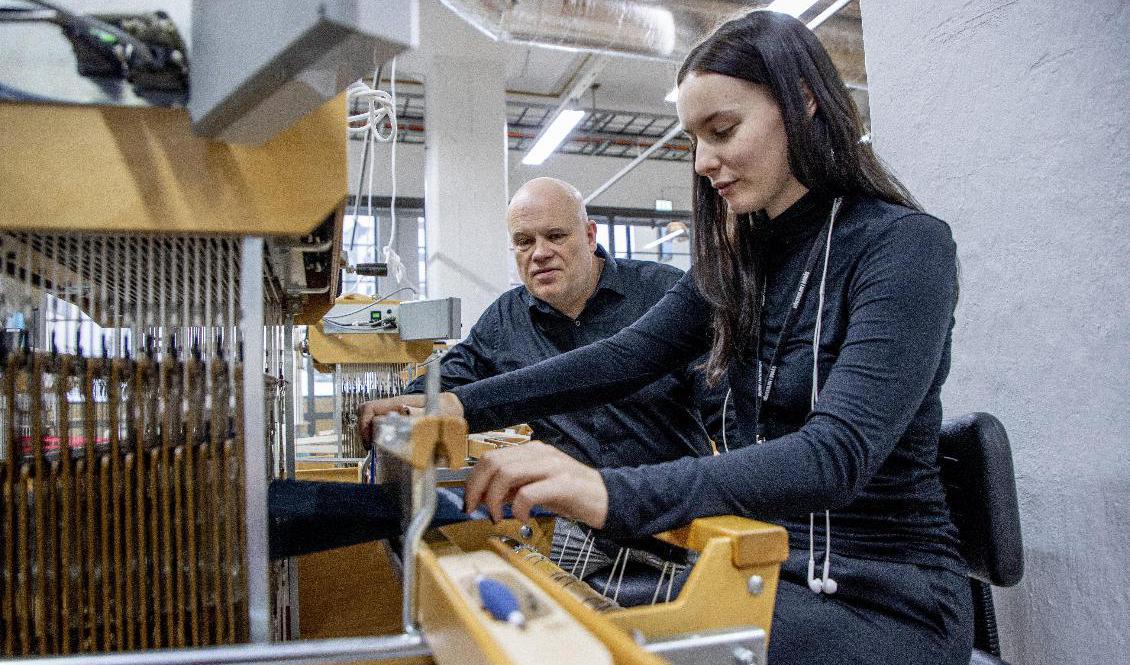 Nils-Krister Persson forskningsledare på Smart Textiles med Carin Backe som är doktorand. Vävstolen är en vanlig vävstol, men här växer olika tekniker för att väva konstgjorda muskler fram. Foto: Adam Ihse/TT