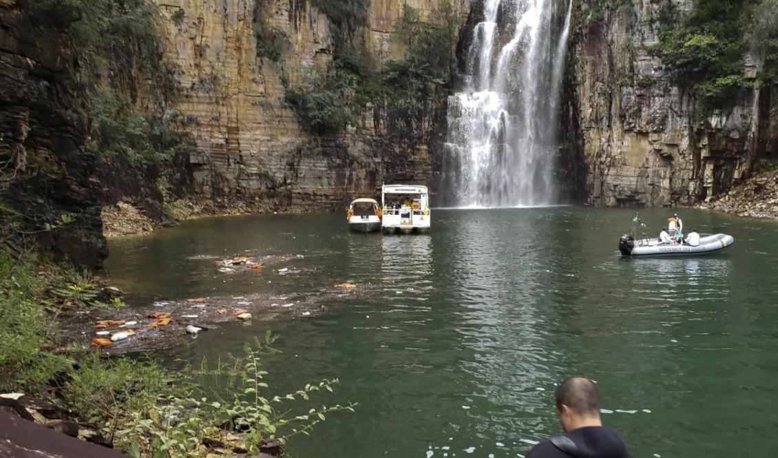 Räddningstjänsten letar efter saknade personer i vattnet efter det att ett klippblock rasat över flera turistbåtar i Brasilien. Foto: Minas Gerais räddningstjänst/handout/AFP/TT