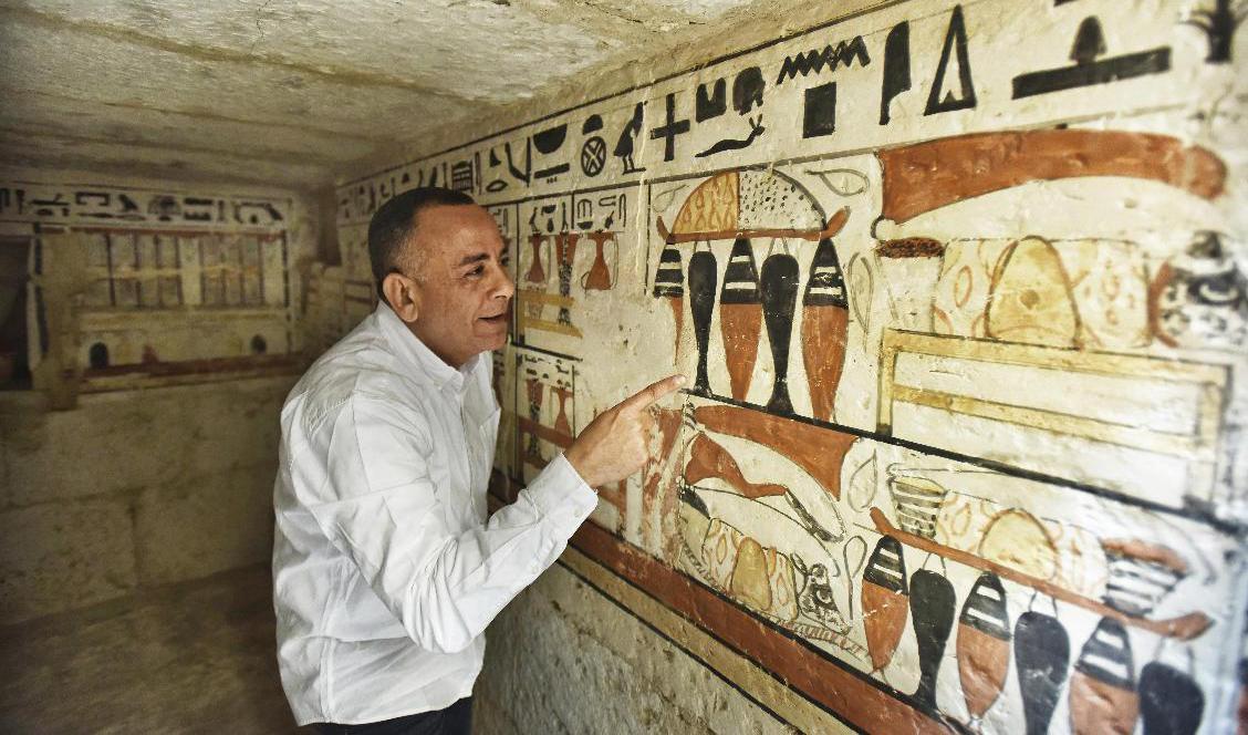 Mostafa Waziri, generalsekreterare för Egyptens antikvitetsmyndighet, tittar närmare på hieroglyferna i en nyligen hittad grav. Foto: Sayed Hassan/AP/TT