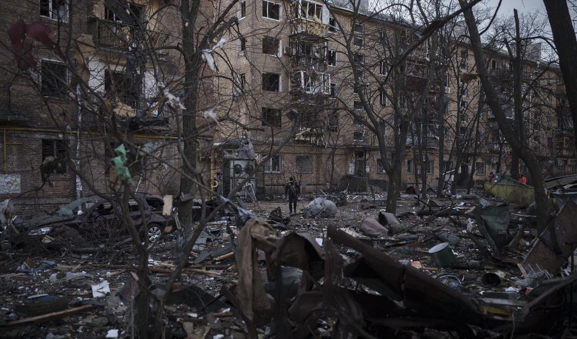 En polis går utanför ett söndersprängt bostadshus i Kiev i fredags. Foto: Felipe Dana/AP/TT