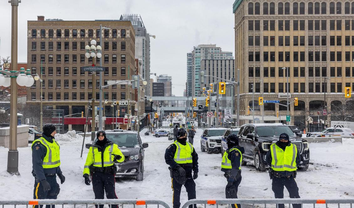 
Polis bevakar en barrikad som satts upp för att bogsera lastbilar som blockerar vägen till Parliament Hill den 19 februari 2022 i Ottawa i Kanada. Foto: Alex Kent/Getty Images                                            