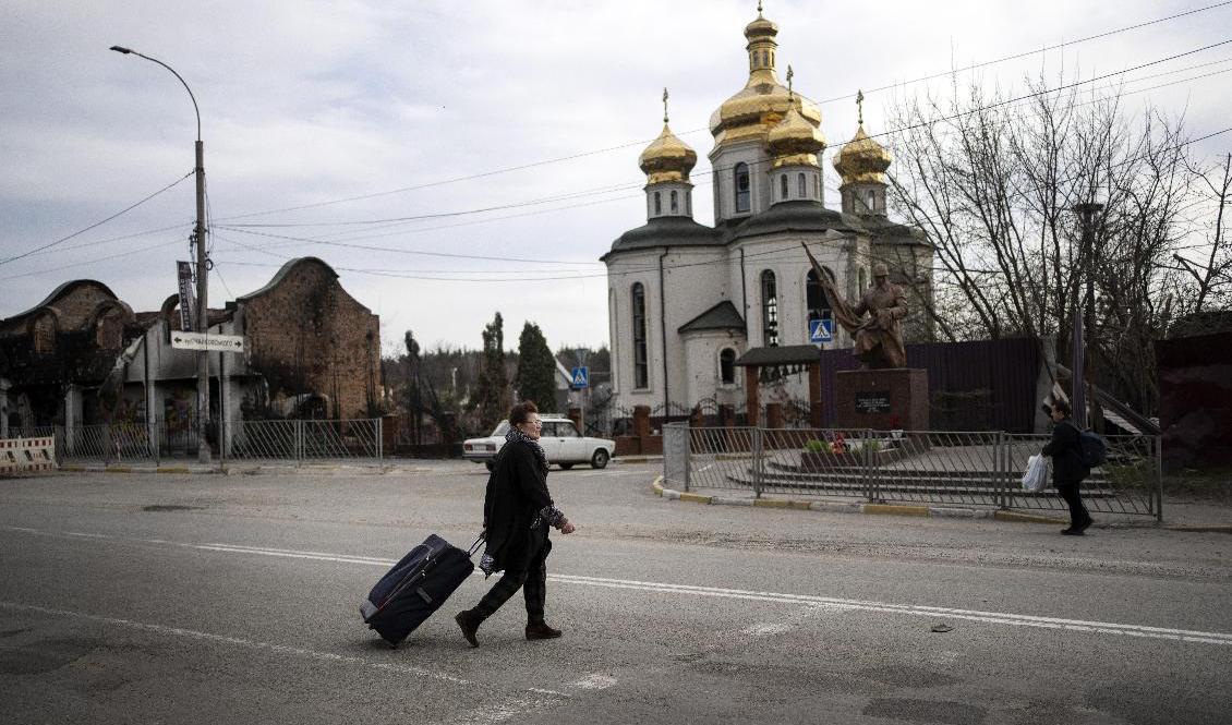 74-åriga Yanina går med sitt bagage mot sitt hus i Irpin, utanför Kiev, i mitten av april. Hon lämnade hemmet i mars, men känner sig nu tillräckligt trygg för att återvända. Foto: Rodrigo Abd/AP/TT