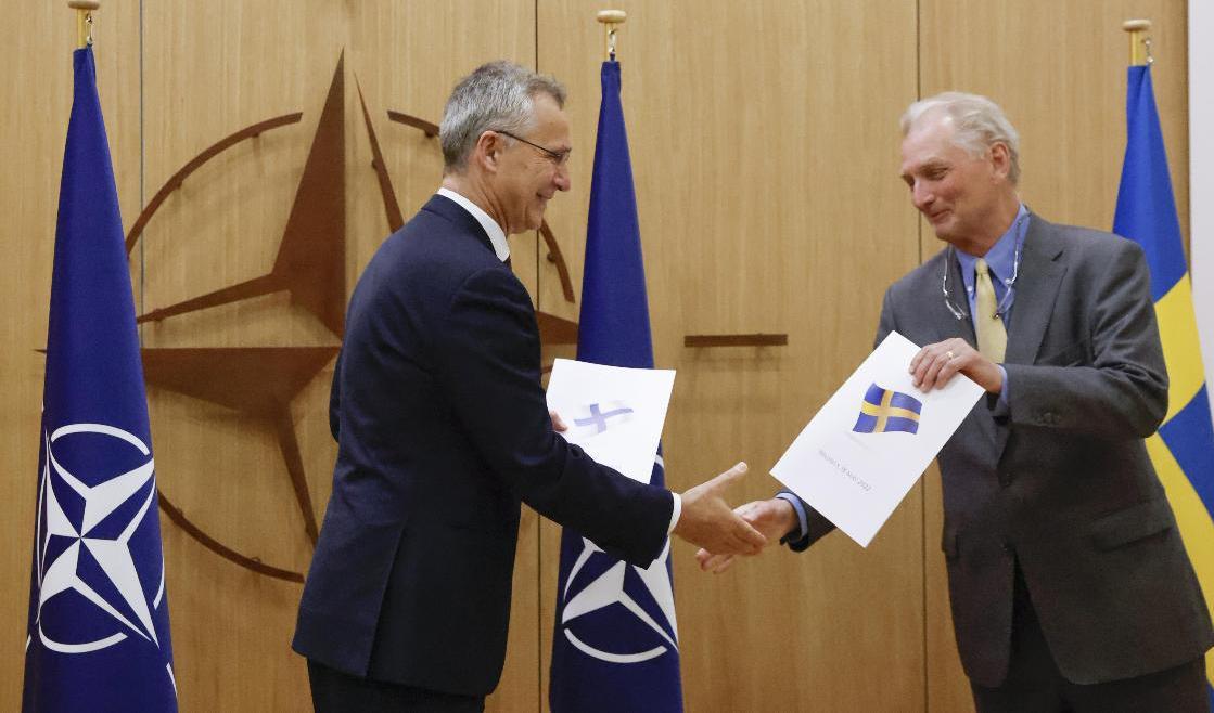 Natos generalsekreterare Jens Stoltenberg tar emot den svenska ansökan om medlemskap i Nato från Sveriges ambassadör Axel Wernhoff. Foto: Johanna Geron/AP/TT