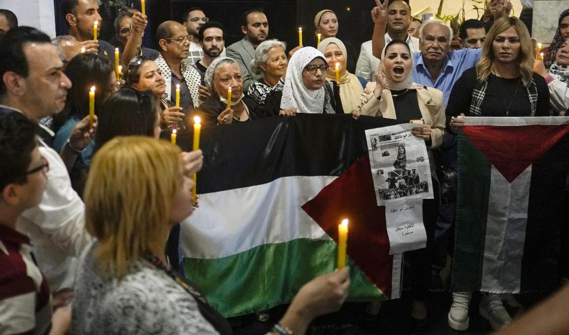 
Människor håller tända ljus och palestinska flaggor vid en minnesstund för den dödade journalisten Shireen Abu Akleh. Bilden togs den 17 maj, en knapp vecka efter det att hon skjutits ihjäl i samband med en israelisk räd i Jenin. Foto: Amr Nabil/AP/TT                                            