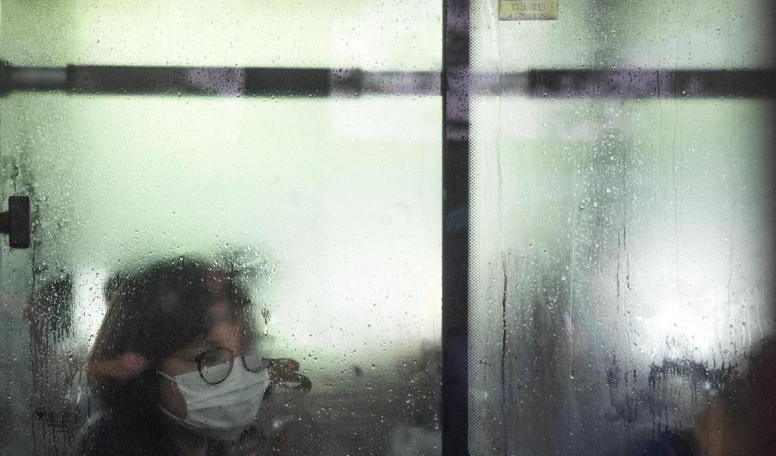 En kvinna med munskydd i Peking under tisdagen. Foto: Mark Schiefelbein/AP/TT