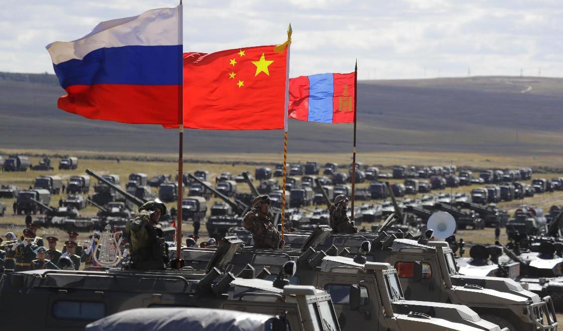
Ryska, kinesiska och mongoliska flaggor vid militärövningen Vostok 2018. Det året deltog 300|000 ryska soldater. Foto: Sergei Grits/AP/TT                                            