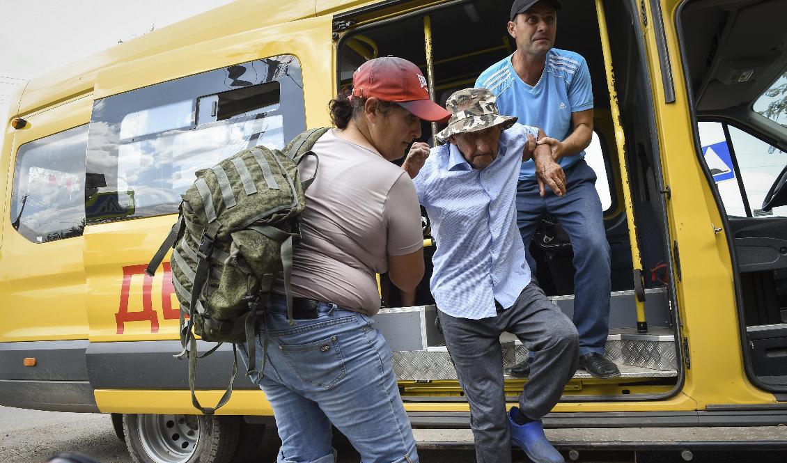En äldre man på ryskannekterade Krim får hjälp att lämna ett område nära en av platserna där det ägde rum en explosion tidigare i veckan. Bilden är från 16 augusti. Foto: Viktor Korotayev/AP/TT
