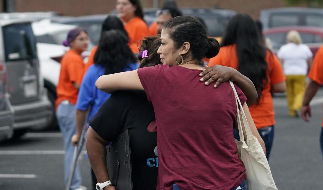 Släkt, förädrar och vänner i Uvalde omfamnar varandra efter beskedet att polischef Pete Arredondo avskedas till följd av sitt agerande under den dödliga massakern på en lågstadieskola. Foto: Eric Gay/AP/TT