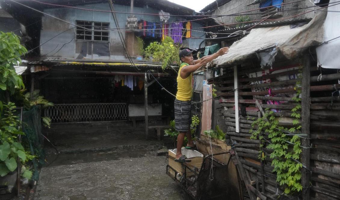 
En boende i det fattiga distriktet Tondo i Manila förstärker sitt tak för att skydda sig mot tyfonen Noru. Foto: Aaron Favila/AP/TT                                            