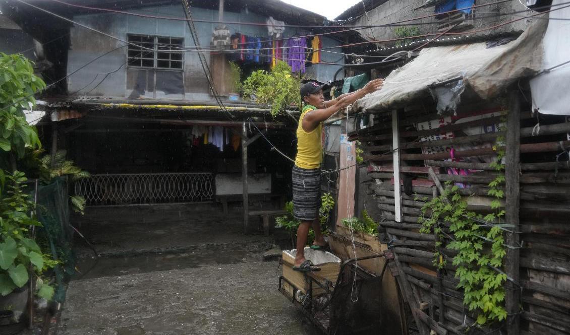 En boende i det fattiga distriktet Tondo i Manila förstärker sitt tak för att skydda sig mot tyfonen Noru. Foto: Aaron Favila/AP/TT