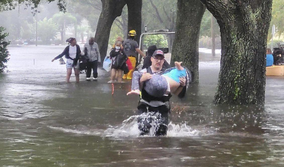 Räddningstjänsten hjälper drabbade i Orange County. Foto: AP/TT