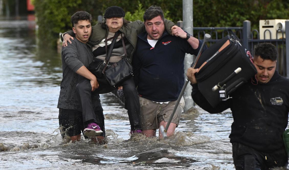 En kvinna får hjälp att lämna Melbourneförorten Maribyrnong i delstaten Victoria, Australien. Foto: Erik Anderson/AAP/AP/TT
