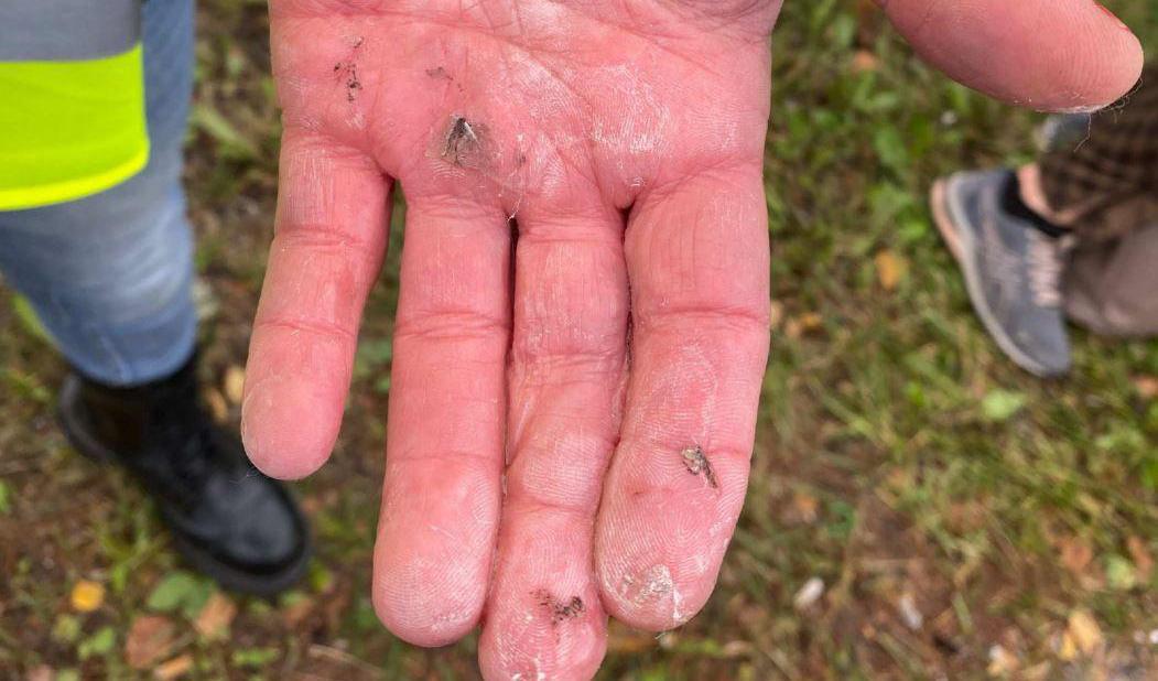 En av aktivisterna visar upp sin hand, som han limmat fast i en av körbanorna vid klimatprotesten på E4. Foto: Foto: Polisens förundersökning/TT