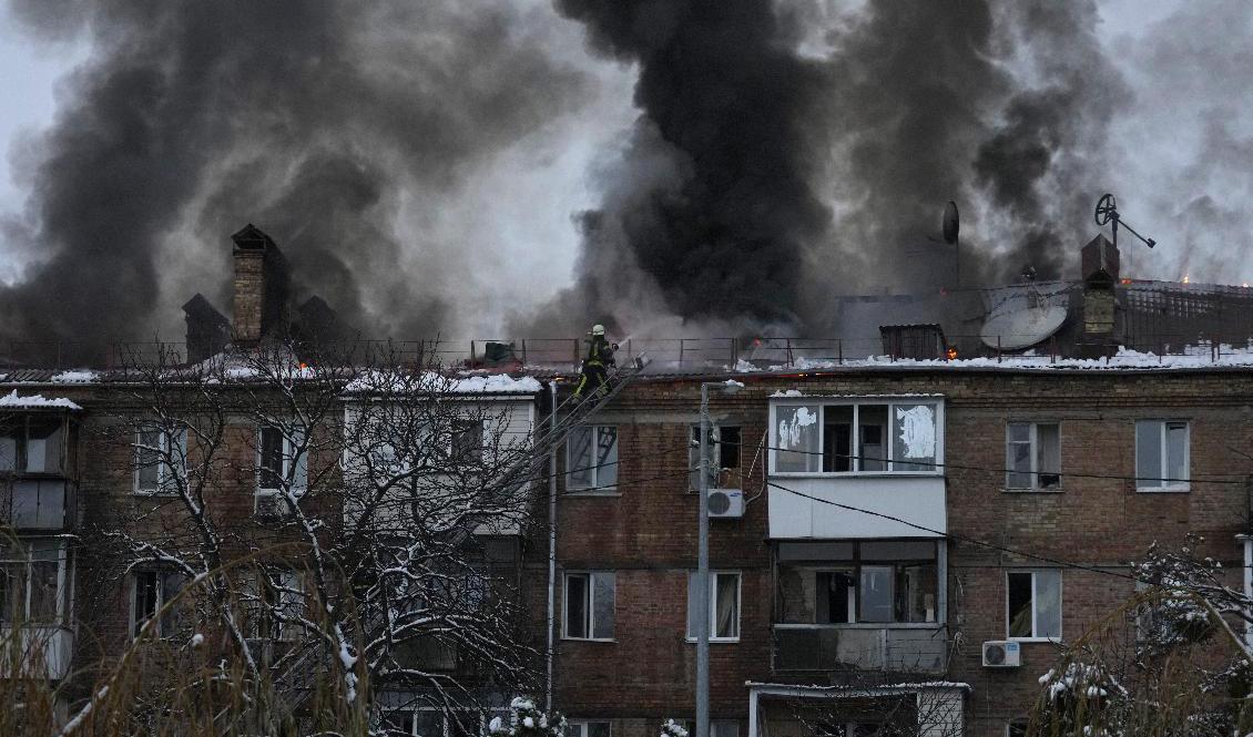 Brandmän kämpar för att släcka elden efter en attack som träffat ett bostadshus utanför Kiev. Foto: Efrem Lukatsky/AP/TT