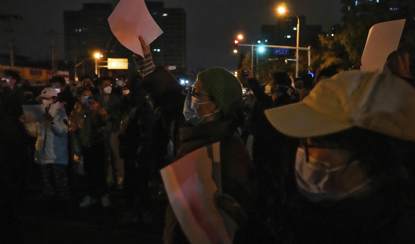 Tomma vita pappersark har under protesterna blivit en symbol för censur. Bilden är från en protest i Peking på söndagskvällen. Foto: Andy Wong/AP/TT