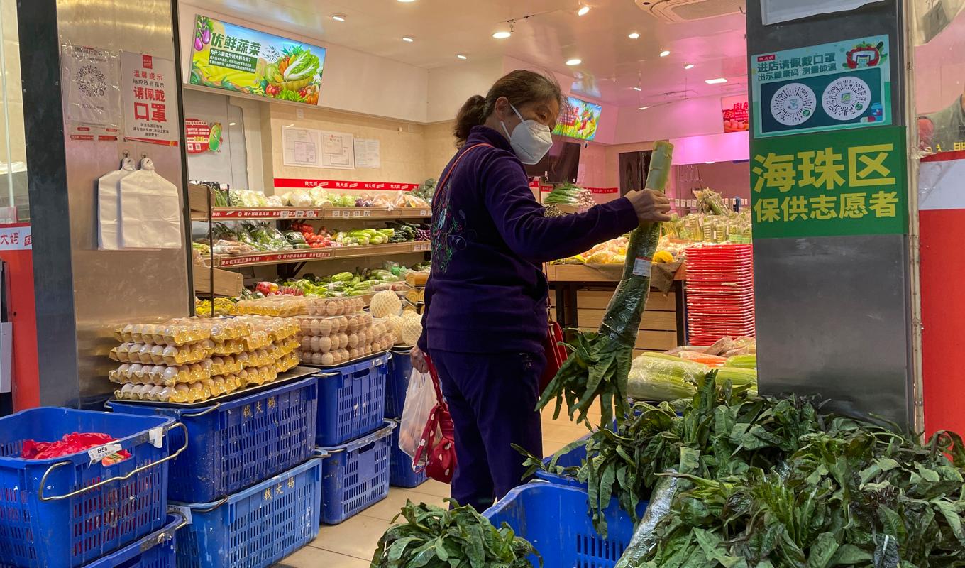 En kvinna i Kanton-provinsen handlar mat under torsdagen sedan en affär öppnat efter de lättade restriktionerna. Foto: AP/TT