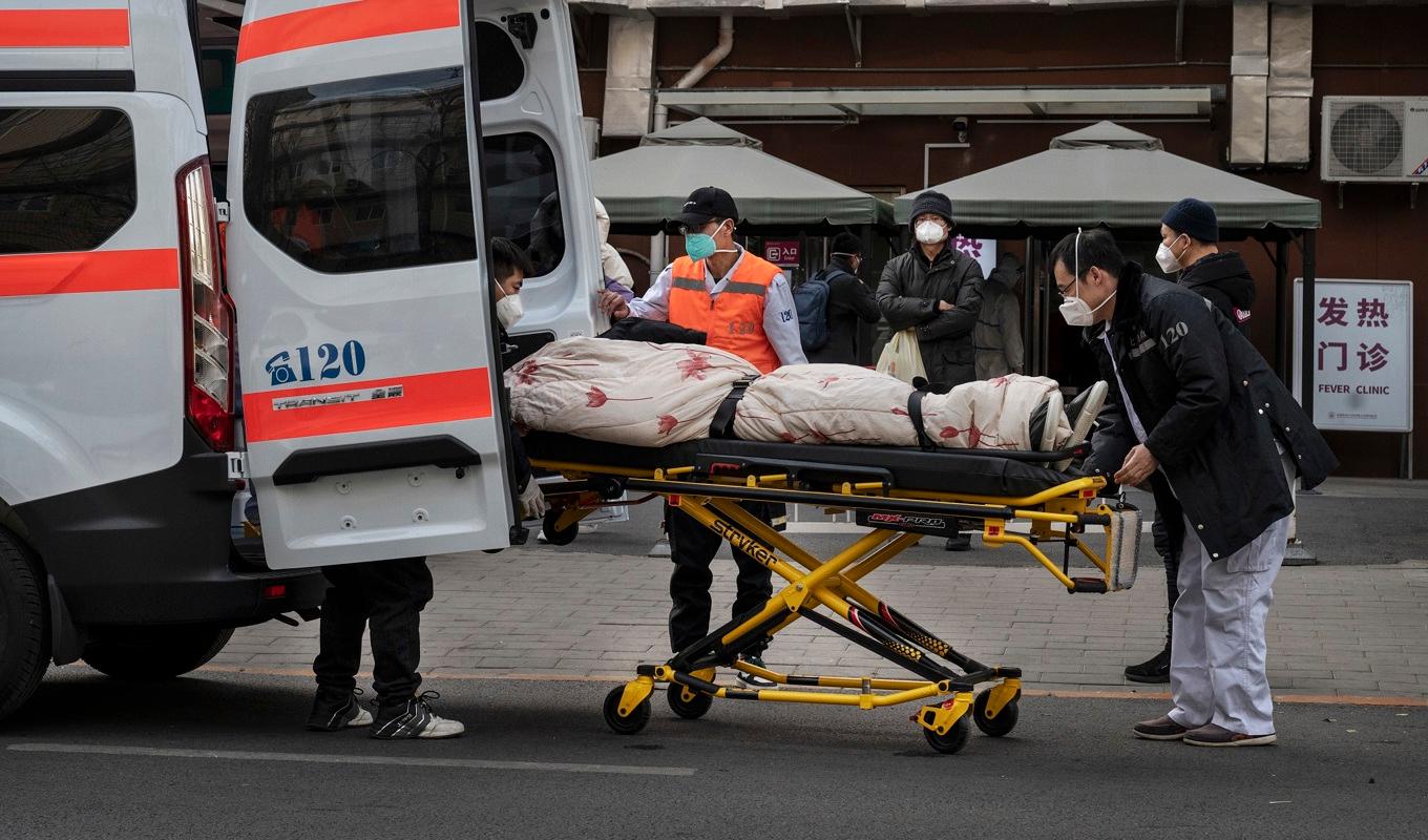 Ambulanspersonal lastar av en patient utanför en klinik som behandlar covid-19-patienter i Peking den 21 december 2022. Foto: Kevin Frayer/Getty Images