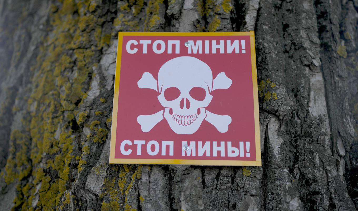 En varningsskylt för att det kan finnas landminor i området. Bilden är från ett område nära Ukrainas huvudstad Kiev i juni förra året. Foto: Natacha Pisarenko/AP/TT