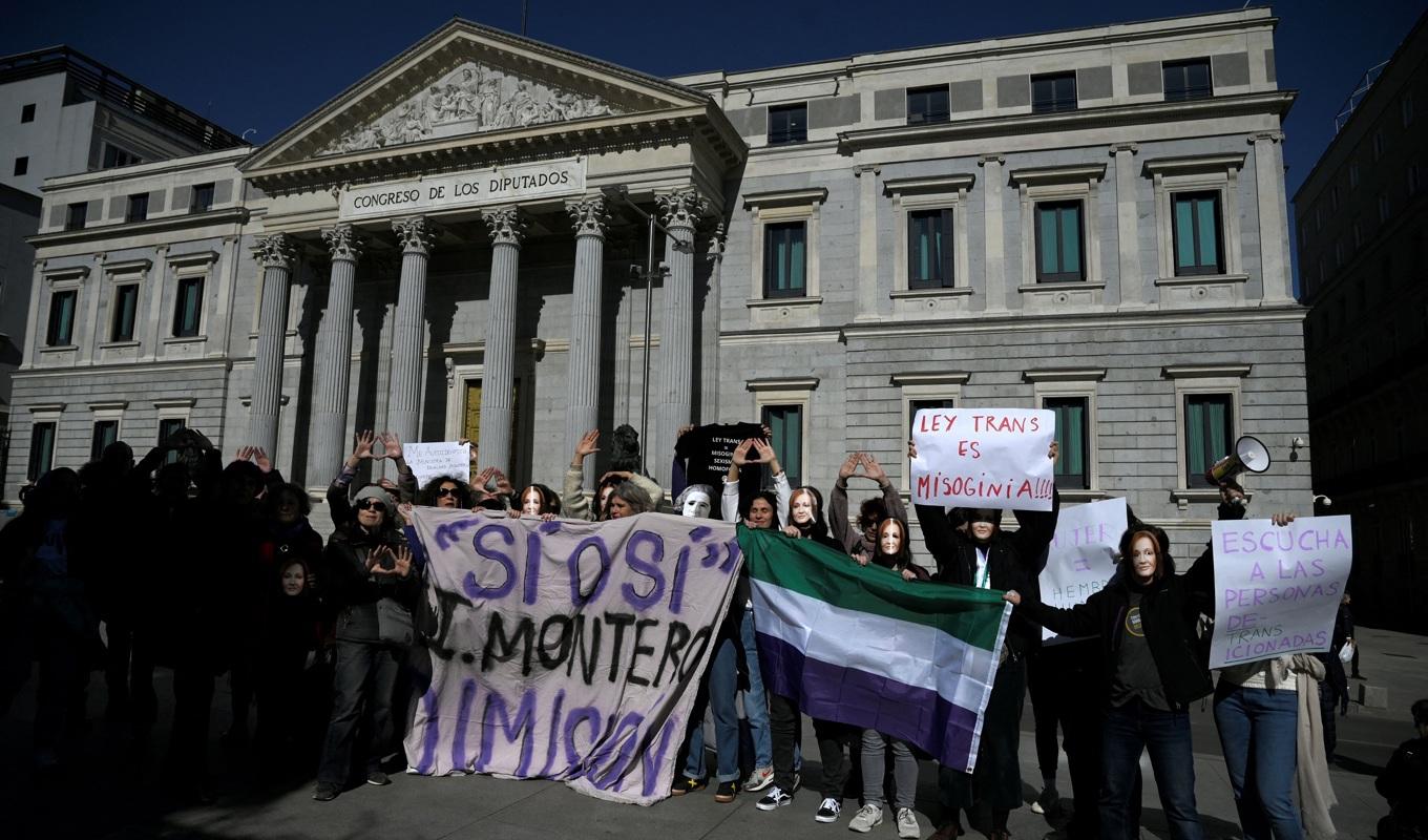 Demonstranter, som håller ett plakat med texten ”Lagen om transpersoner är kvinnofientlig”, protesterar mot lagen om transpersoners rätt att bestämma sin könsidentitet framför spanska kongressen i Madrid den 16 februari 2023. Foto: Oscar del Pozo/AFP via Getty Images
