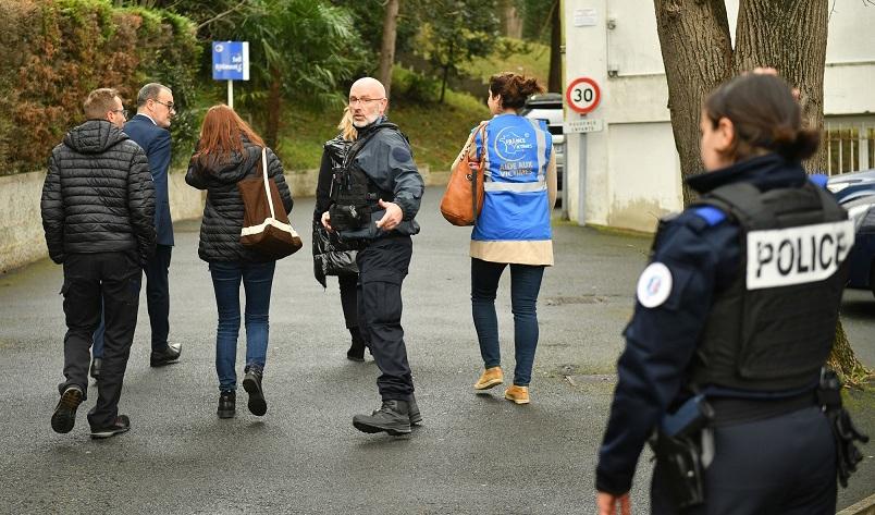 Polis och en person som arbetar för att stödja offer står vid ingången till skolan Saint-Thomas-d'Aquin i Saint-Jean-de-Luz i sydvästra Frankrike. Foto: Gaizka Iroz/AFP via Getty Images