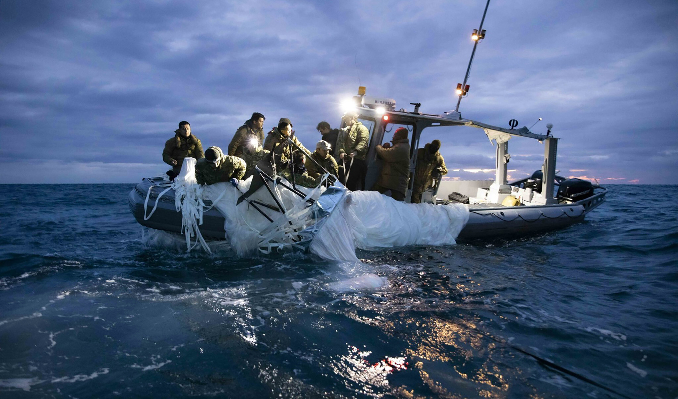 En grupp specialutbildade soldater plockar upp ballongen ur Atlanten. Foto: Amerikanska flottan/AP/TT