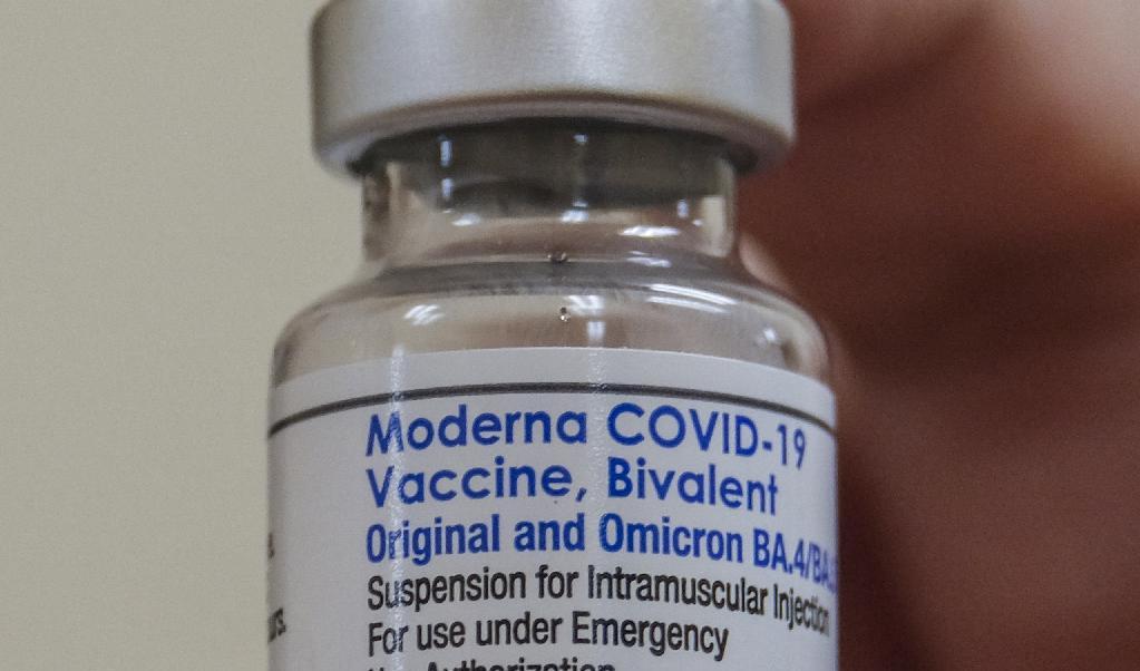 Farmaceut håller upp en flaska med dubbelverkande covid-19-vaccin från det amerikanska läkemedelsföretaget Moderna. Foto: Ringo Chiu/AFP via Getty Images