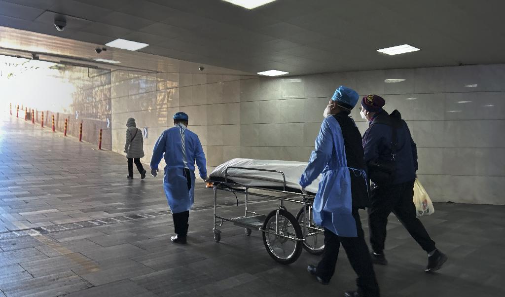 En kropp rullas ut från en akutavdelning på ett sjukhus i Peking, i januari. Många kineser ifrågasätter dödstalen i den pågående covidvågen. Foto: Getty Images