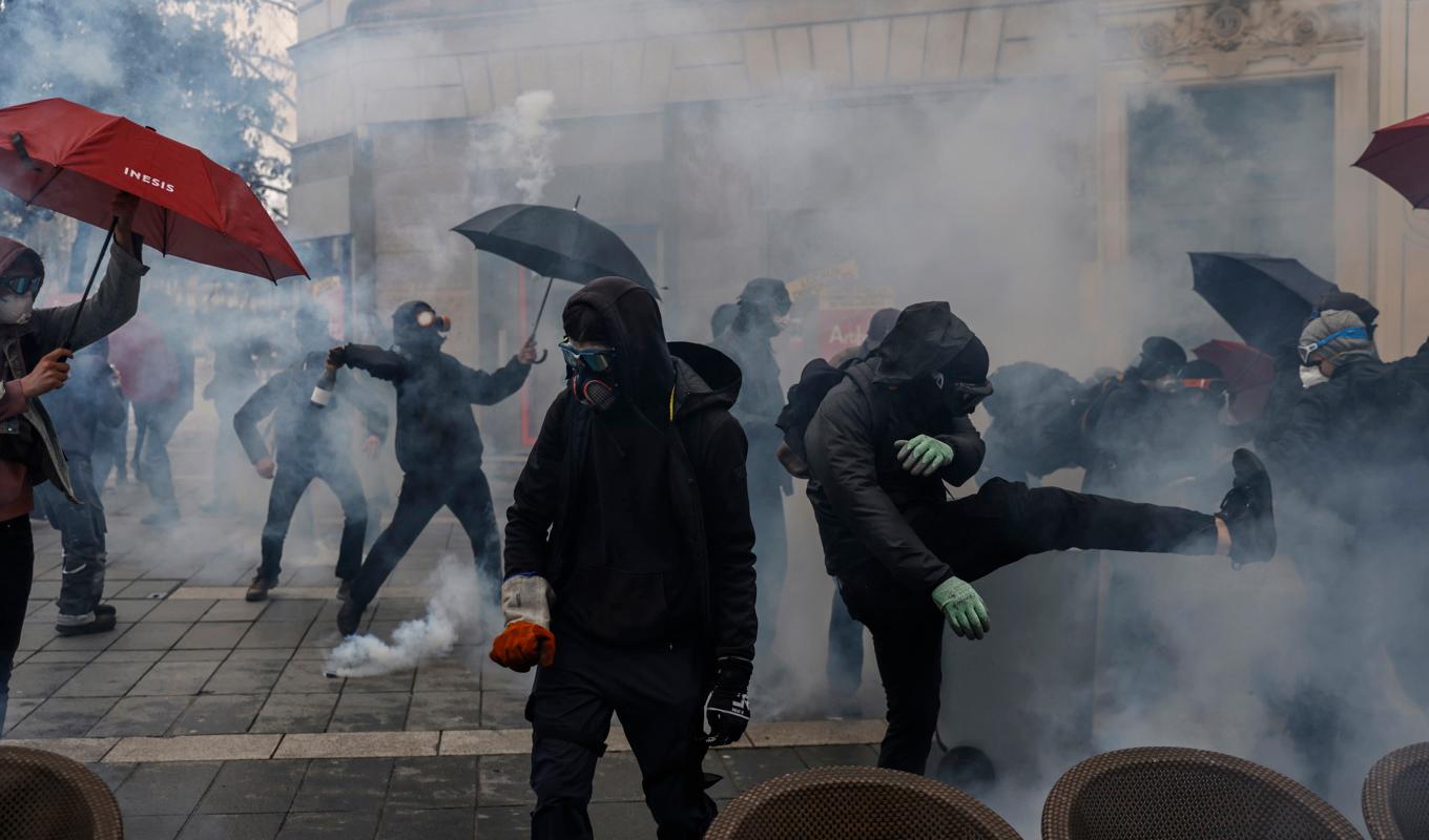 Demonstranter drabbar samman med polis i en dimma av tårgas. Bilden är tagen i Nantes i västra Frankrike. Foto: Jeremias Gonzalez/AP/TT
