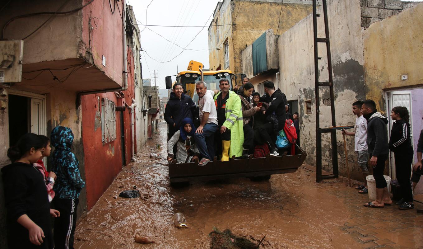 Invånare får hjälp i Sanliurfa, Turkiet, som drabbats av översvämningar. Foto: Hakan Akgun/AP/TT