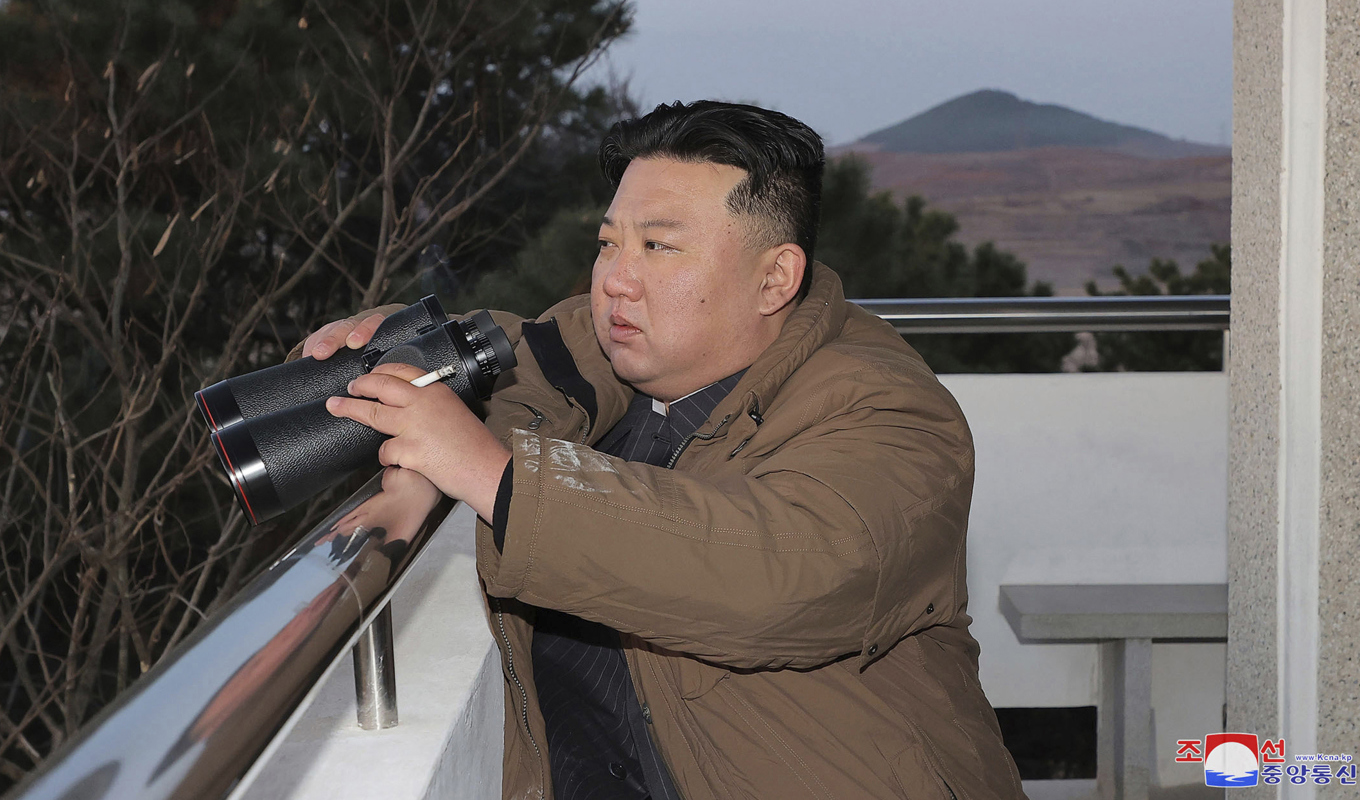 På den här bilden, som har distribuerats av den nordkoreanska regimen, syns landets diktator Kim Jong-Un med en kikare vid ett robottest i torsdags. Foto: Nordkoreanska KCNA via AP/TT